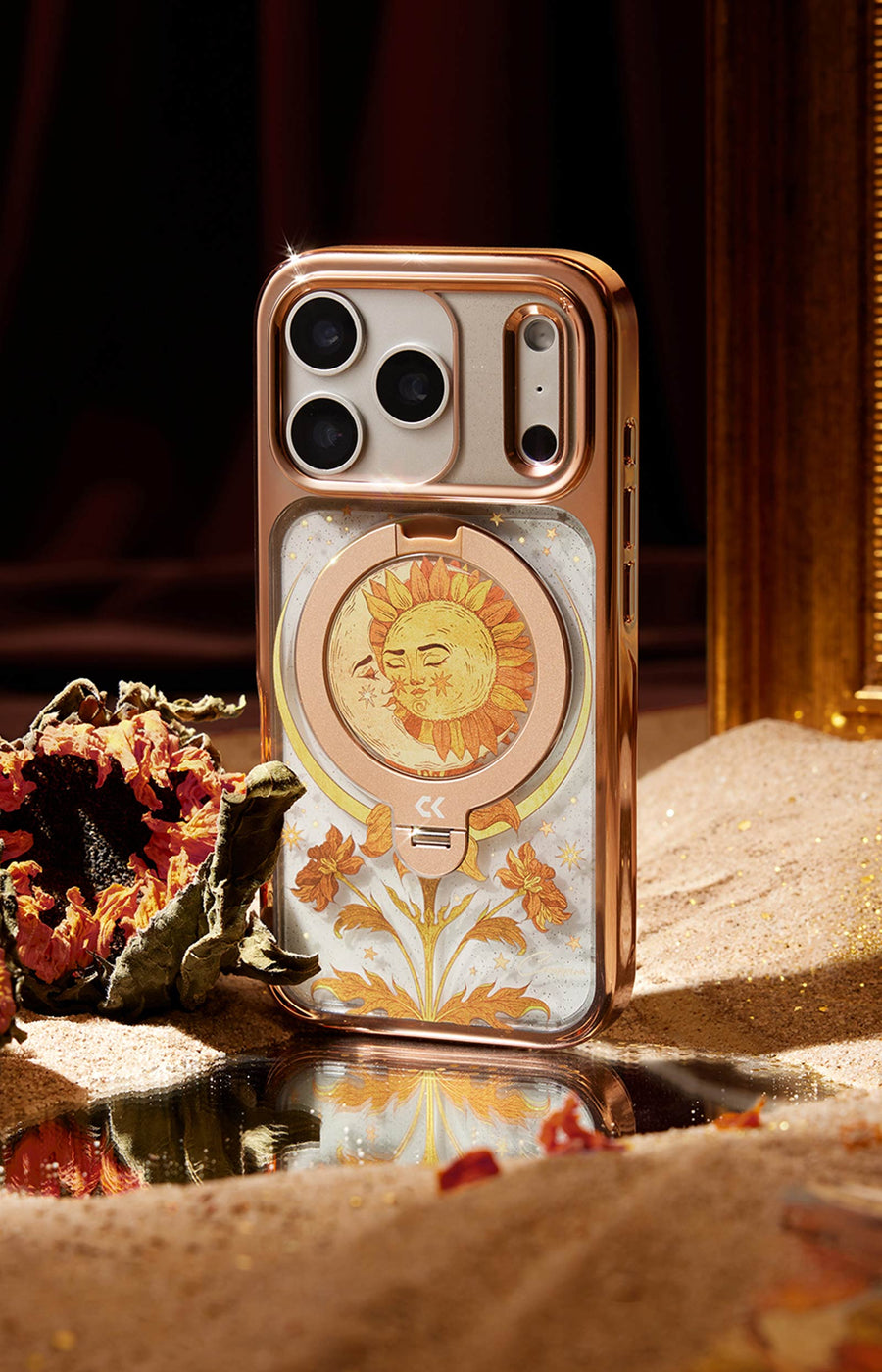 Phone case with floral design and sun illustration on a reflective surface.